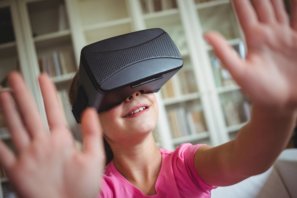 Girl looking through virtual reality headset in living room at home